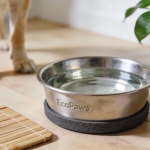 EcoPaws stainless steel pet bowl with non‑slip base filled with water on a wooden floor beside a bamboo mat